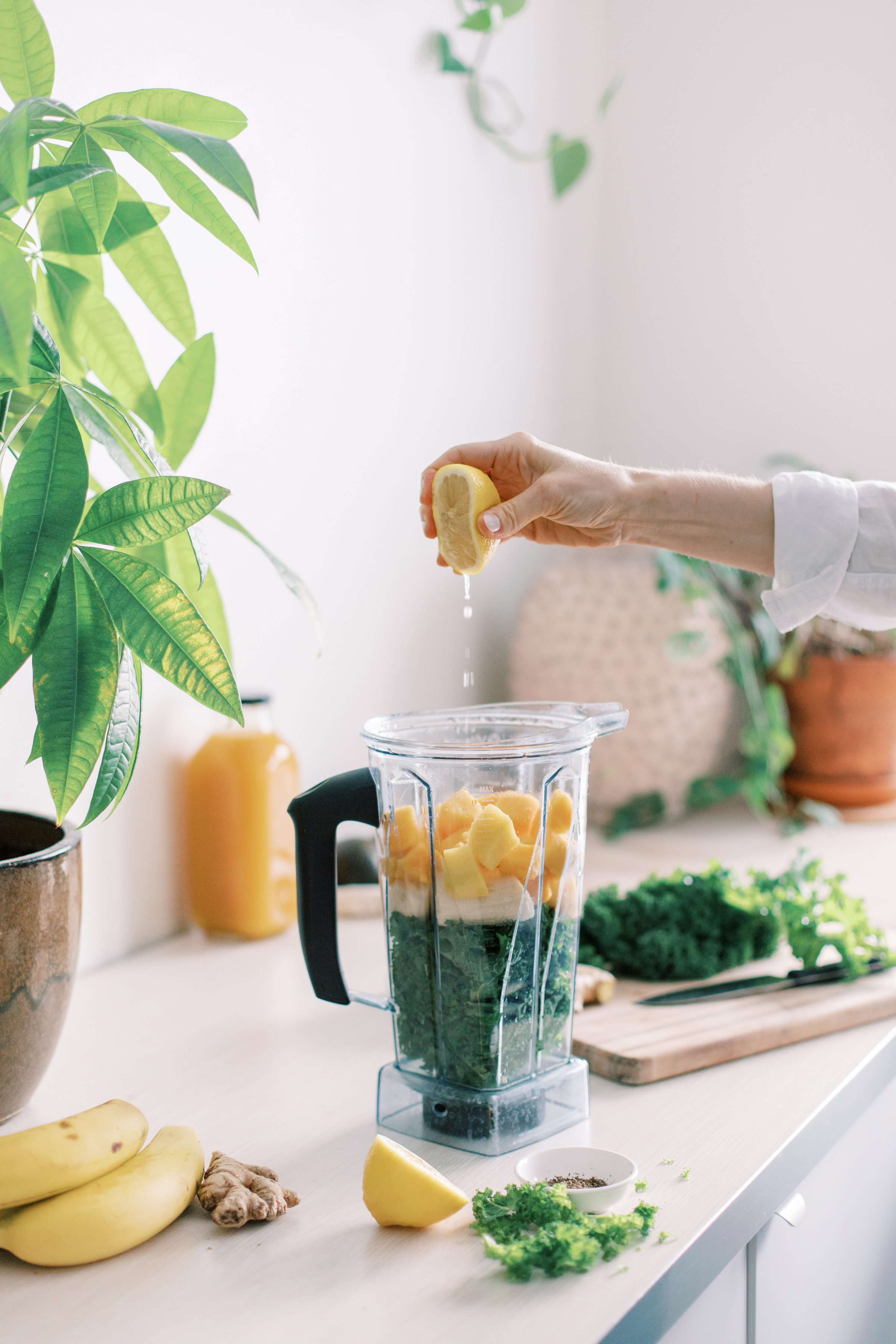 Healthy fruit and veg smoothie with a hand squeezing a lemon